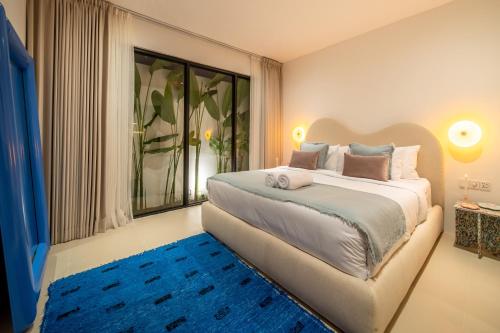 a bedroom with a large bed and a blue rug at Casa Dala Canggu in Canggu