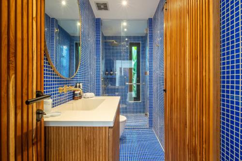 a blue tiled bathroom with a sink and a shower at Casa Dala Canggu in Canggu