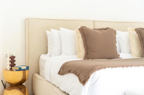 a bed with white sheets and pillows on it at Casa Dala Canggu in Canggu