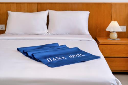 Una cama con una almohada azul encima. en Hana Hotel Sonasea Night Market Phu Quoc en Phu Quoc