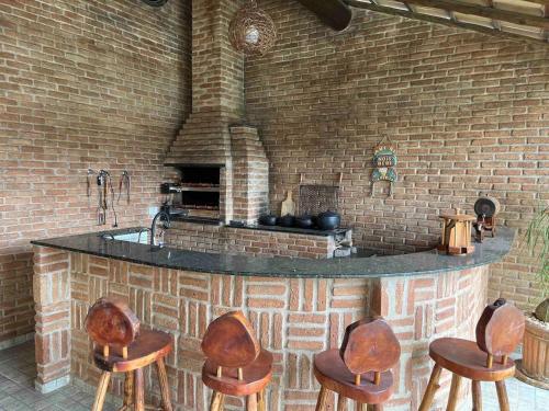 een keuken met een bar met vier stoelen eromheen bij Estância Zuliani in Guriri