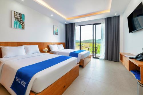 a hotel room with two beds and a television at Hana Hotel Sonasea Night Market Phu Quoc in Phú Quốc