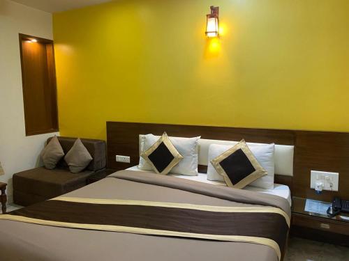 a bedroom with a bed and a yellow wall at Svaruchi Inn in New Delhi