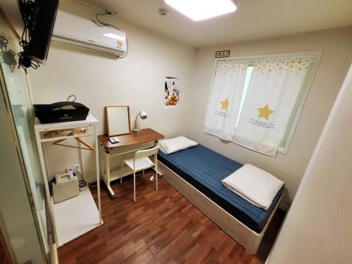 Habitación pequeña con cama y escritorio. en 24 Guesthouse Sinchon Avenue, en Seúl