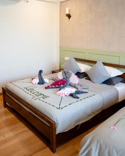 a bedroom with two beds with stuffed animals on it at Ahola Thoddoo, Maldives in Thoddoo