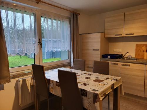 a kitchen with a table and chairs and a window at Lanckensburg - Ferienwohnung 1 in Altenkirchen