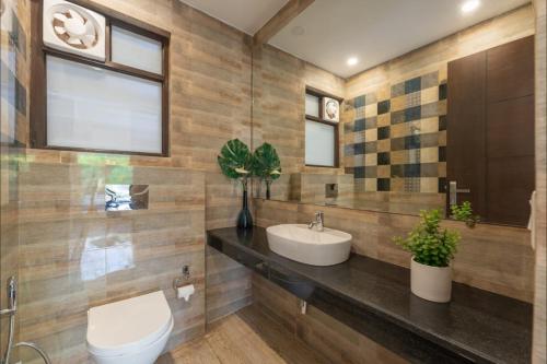 a bathroom with a sink and a toilet at Luxury Apartments with Swimming Pool near Candolim Beach in Candolim
