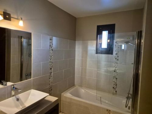 une salle de bain avec une douche, une baignoire et un lavabo dans l'établissement Villa avec piscine dans un domaine viticole, à Domazan