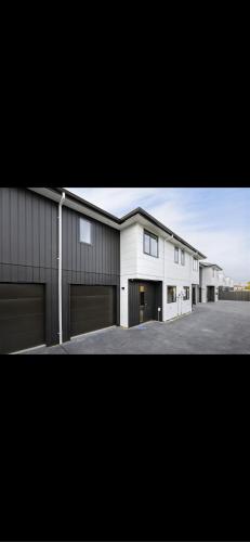 a large white house with two garage at Hamilton New Town House in Hamilton