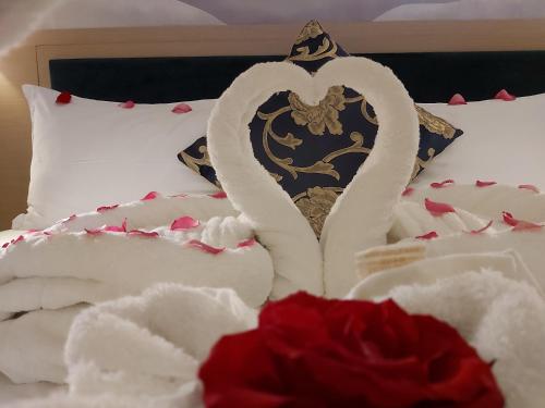a bed with two white swans making a heart at Season Inn Hotel in Barka