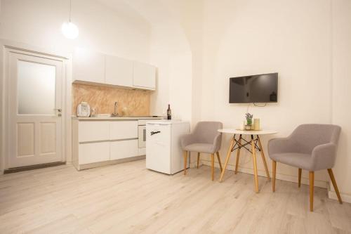 een keuken met twee stoelen en een tafel en een televisie bij Luxury Ultra Central in Sibiu