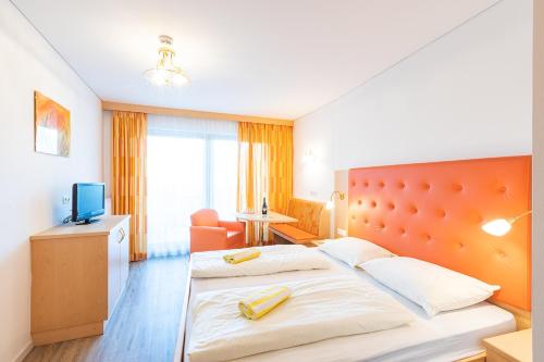 a hotel room with a bed and a television at Hotel Winzerhof in Termeno
