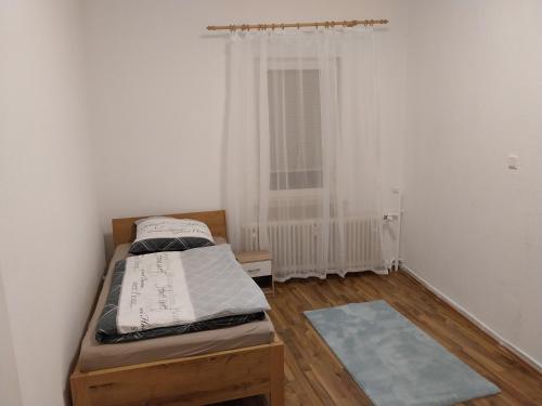 ein kleines Schlafzimmer mit einem Bett und einem Fenster in der Unterkunft 3 Zimmer Monteurwohnung 1 Etage in Riedstadt
