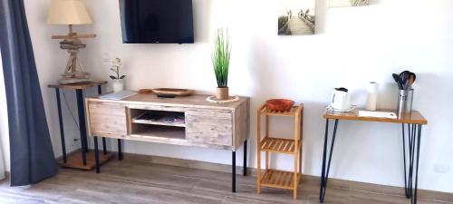 a wooden dresser with a plant on top of it at Studio standing classé meublé de tourisme avec terrasse vue mer " les pieds dans l'eau " à Algajola in Algajola