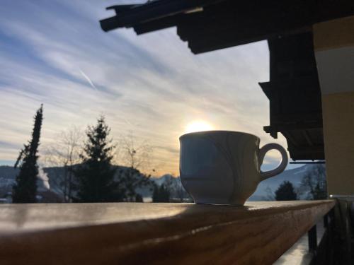 a coffee cup sitting on a table in front of a window at Seeblick Faaker See in Drobollach am Faakersee