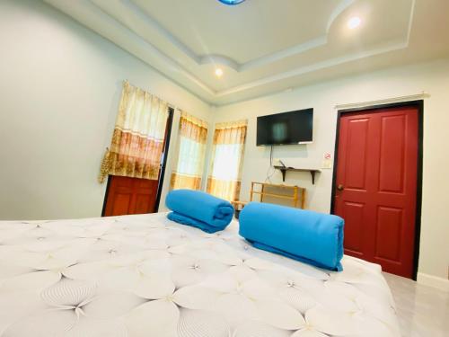 a bedroom with a large bed with blue chairs and a tv at Panutsaya Homestay in Wang Nam Khieo