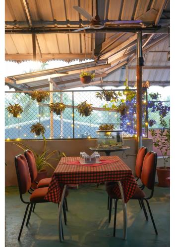 a dining room with a table and chairs and plants at Hotel Aramana in Kāladi