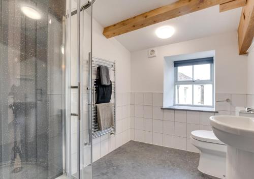 a bathroom with a shower and a toilet and a sink at The Barn at the Grange in Hawes