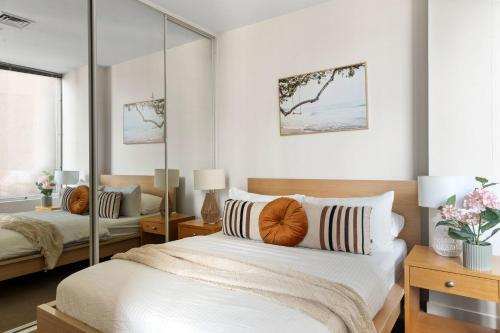 a bedroom with a large bed with a mirror at A Stylish & Central 2BR Apt Near Flinders Station in Melbourne