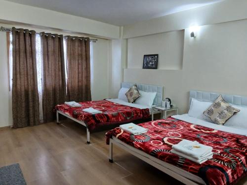 Habitación de hotel con 2 camas y ventana en New Maya Residency, en Darjeeling