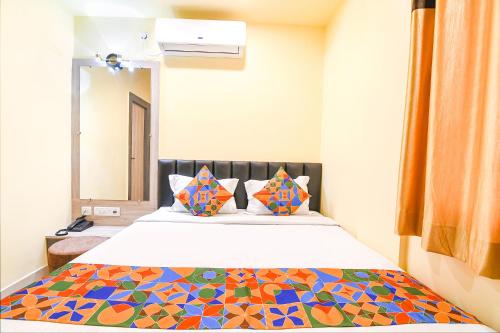 a bedroom with a bed with a colorful blanket at FabHotel Bypass View in Kolkata