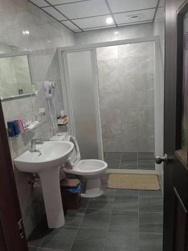een badkamer met een toilet, een wastafel en een douche bij Beautiful Guest House II in Chin-sha