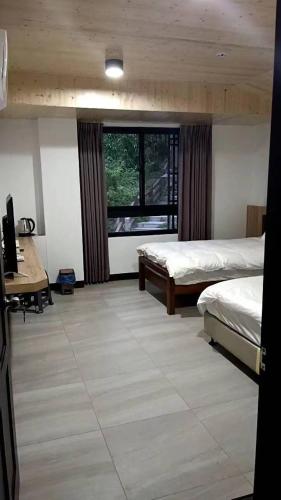 Chin-shaにあるBeautiful Guest House IIのベッド2台と机と窓のある寝室