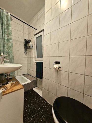 a bathroom with a black toilet and a sink at Apartment Sophia in Hamm