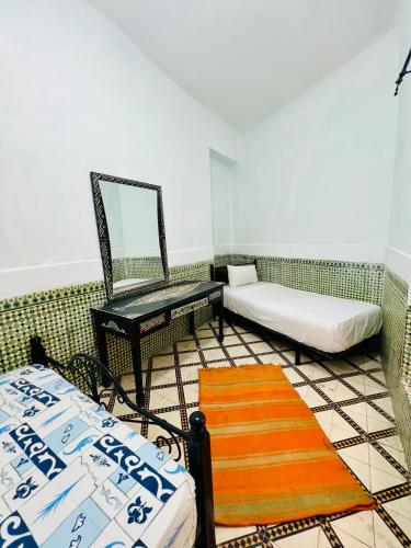 Pokój z 2 łóżkami, lustrem i krzesłem w obiekcie apartement jamaa el fana w Marakeszu