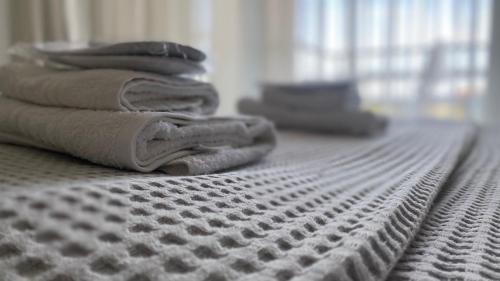 メッシーニにあるMessini Hotelのベッドの上に座るタオルの山
