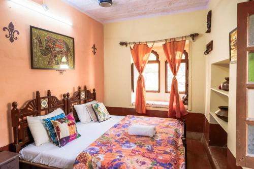 1 dormitorio con 1 cama con paredes de color naranja en Sagar Guest House en Jaisalmer