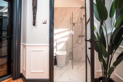 a bathroom with a toilet and a glass shower door at East Cliff in Preston