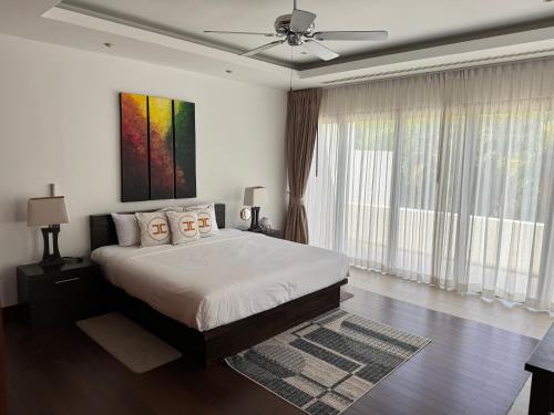 a bedroom with a bed and a ceiling fan at Wonderful villa Harmony BangTao beach in Bang Tao Beach