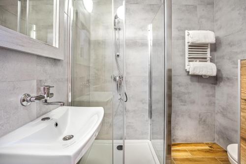 La salle de bains est pourvue d'un lavabo et d'une douche. dans l'établissement Nova Fala, à Łeba