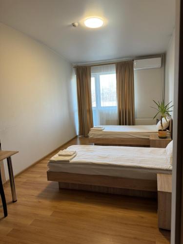 1 dormitorio con 2 camas y ventana en Laguna, en Lutsk