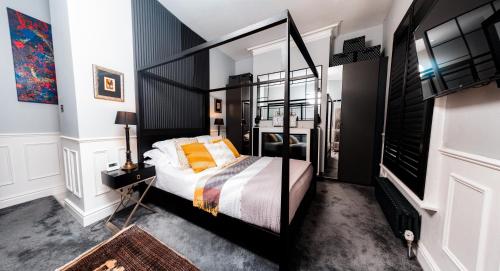a bedroom with a black and white bed with orange pillows at East Cliff in Preston