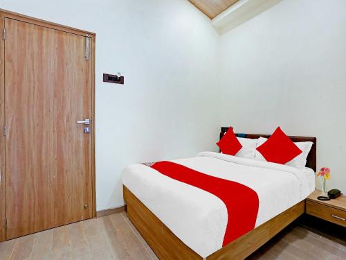 a bedroom with a large bed with red pillows at Malali Residency in Mumbai