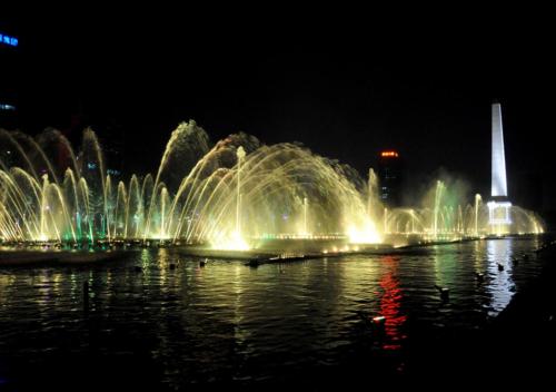 a fountain in the water with a city at night at Wuyu Hotel - Chongqing Liangjiang Happiness Plaza & Xingfu Square & GuangdianYuan metro in Chongqing