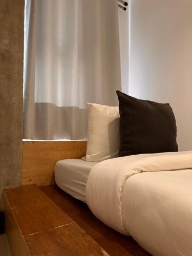 a bed with a black pillow and a window at Urban Boutique Hotel in Boracay