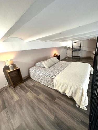 - une chambre avec un grand lit et du parquet dans l'établissement Les Platanes, à Cassis