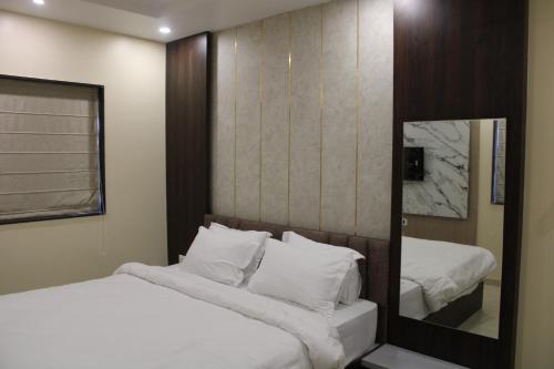 a bedroom with two beds and a mirror at Hotel Veeratn in Kolhapur