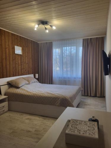 a bedroom with a bed and a ceiling fan at Poilsis dviems in Šiauliai