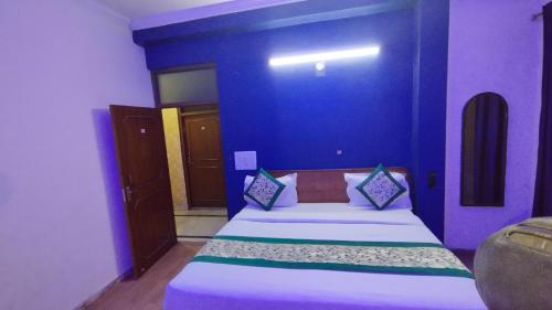 - une chambre dotée d'un lit avec un mur bleu dans l'établissement Hotel The Grace Near Delhi Airport, à New Delhi