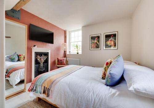 a bedroom with a bed and a tv on the wall at No.1 Baileygate Cottages in Castle Acre