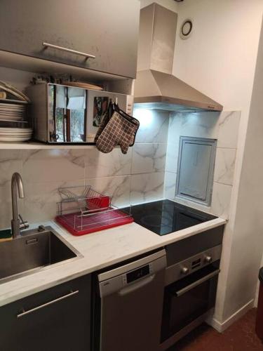 une petite cuisine avec un évier et une cuisinière dans l'établissement 2 pers. Paris Sacré Coeur, à Paris