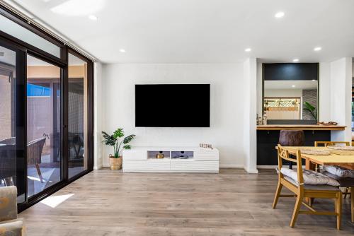 a living room with a tv on a wall at Swainson on Lady Gowrie in Largs
