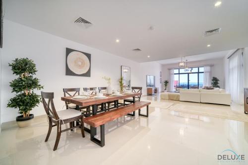 een eetkamer met een tafel en stoelen bij Lavish 4BR Villa with 2 Assistant Rooms, Al Dana Island, Fujairah by Deluxe Holiday Homes in Fujairah