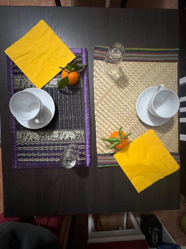 a table with two plates and yellow napkins on it at Affittacamere Ca' de Mazapedar in San Lorenzo