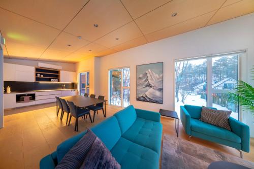 a living room with a blue couch and a table at Blue River Chalets by The Hakuba Collection in Hakuba