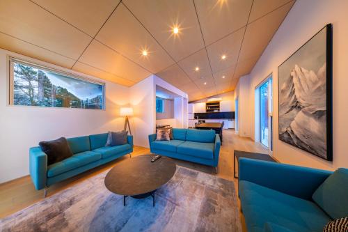 a living room with blue couches and a table at Blue River Chalets by The Hakuba Collection in Hakuba